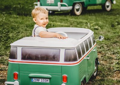 Junge Kinderbulli VW T1 Bus Elektroauto Kinderauto Weißwandreifen Wiese