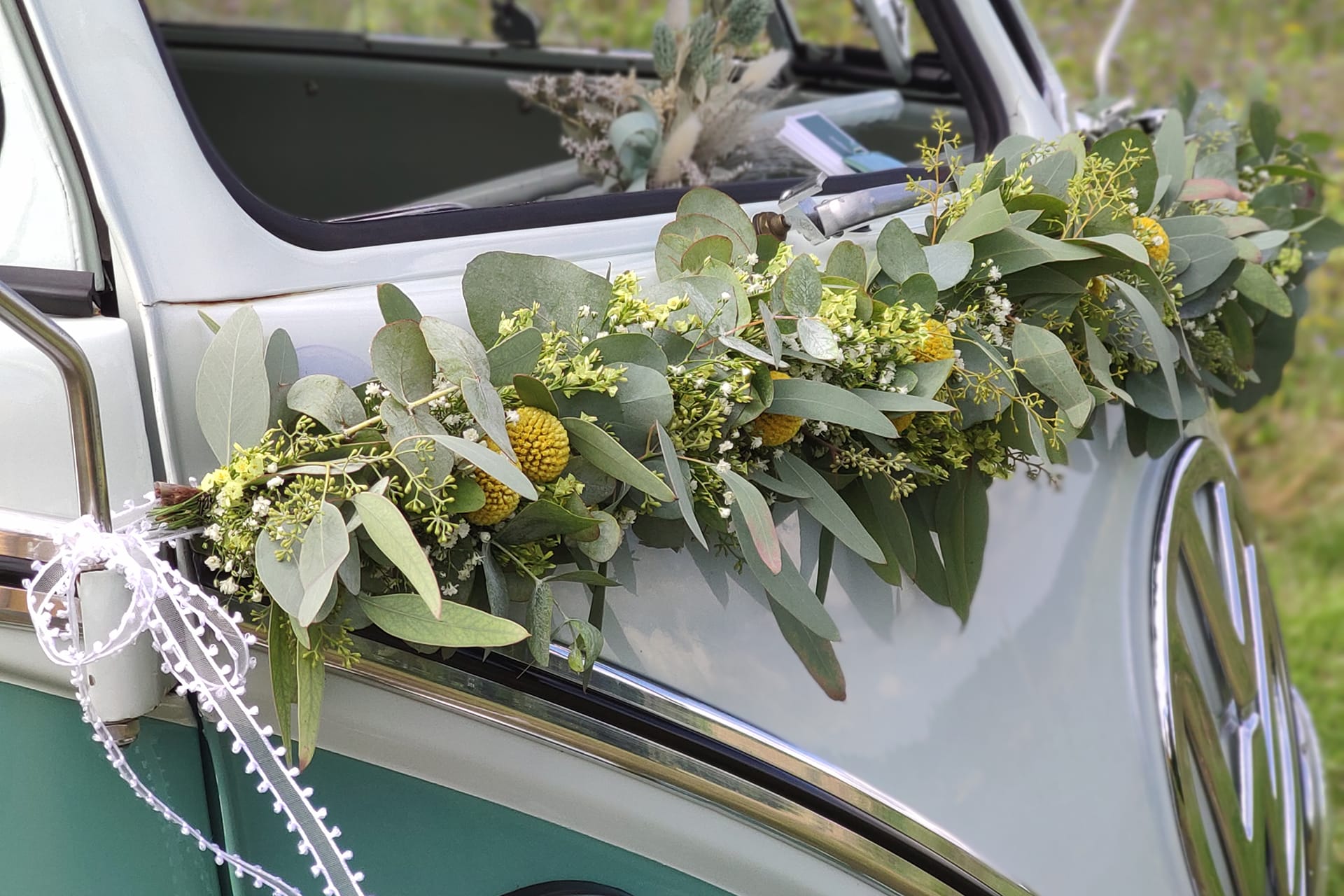 Echtblumengirlande in gelb, weiß mit Eukalyptus und Craspedia an einem Hochzeitsauto VW T1